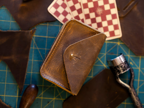 Standard Issue Leather Case on a green cutting mat with a checkered Tarot for Bros™ card back and leather scraps, shown for the Deck + Case Bundle